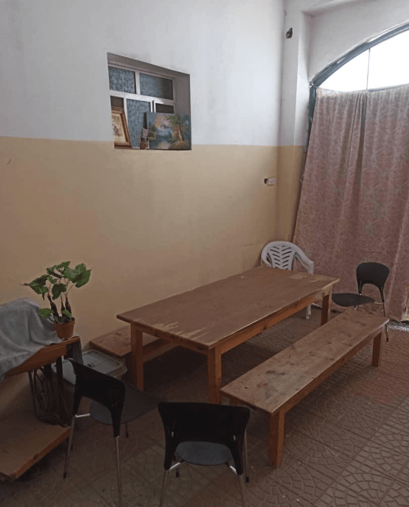 The empty garage classroom with a long wooden table